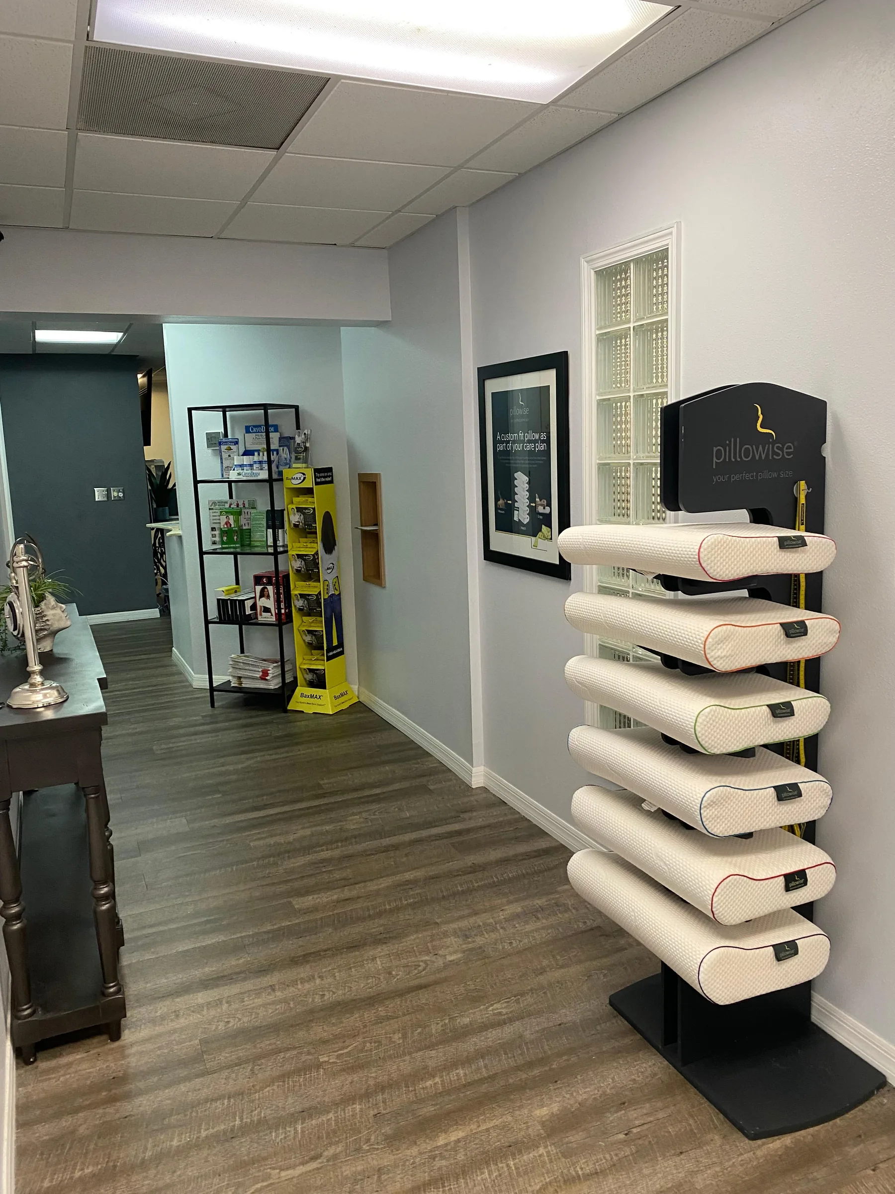 Pillowise pillow display stand with stacked white pillows in a chiropractic office showroom.